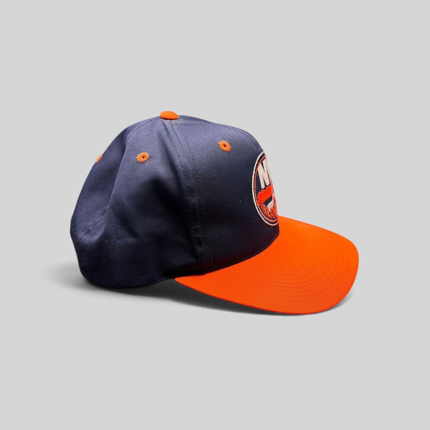 Raree Finds vintage 1990s New York Islanders snapback hat in navy and orange with embroidered team logo and green brim