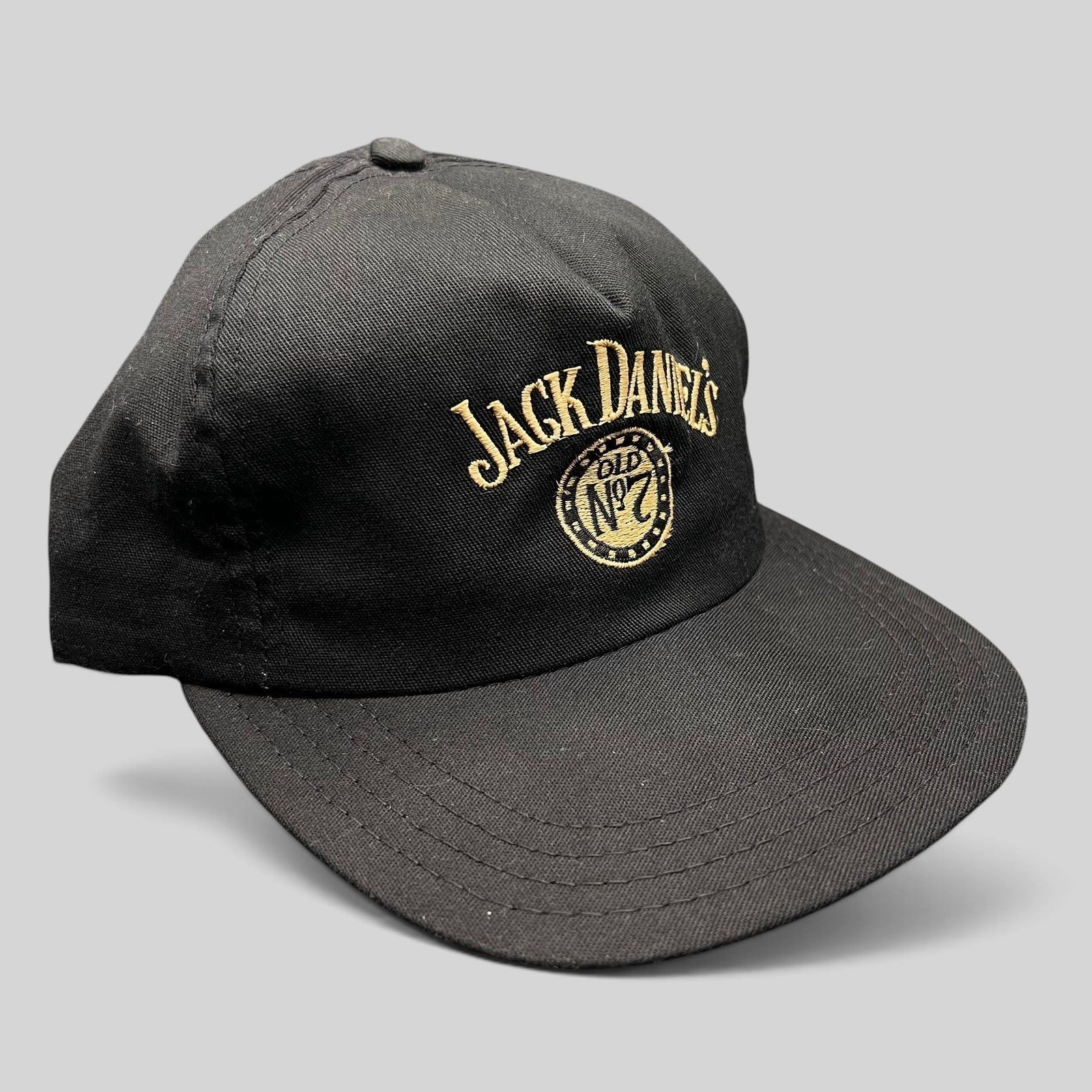 Raree Finds vintage 90s Jack Daniel’s black snapback hat with gold embroidered Old No. 7 logo and arched script