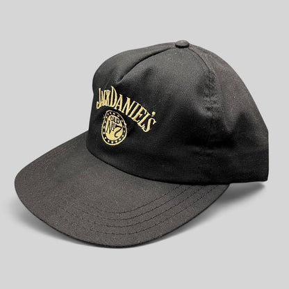 Raree Finds vintage 90s black Jack Daniel’s snapback hat with gold embroidered Old No. 7 logo and curved visor.