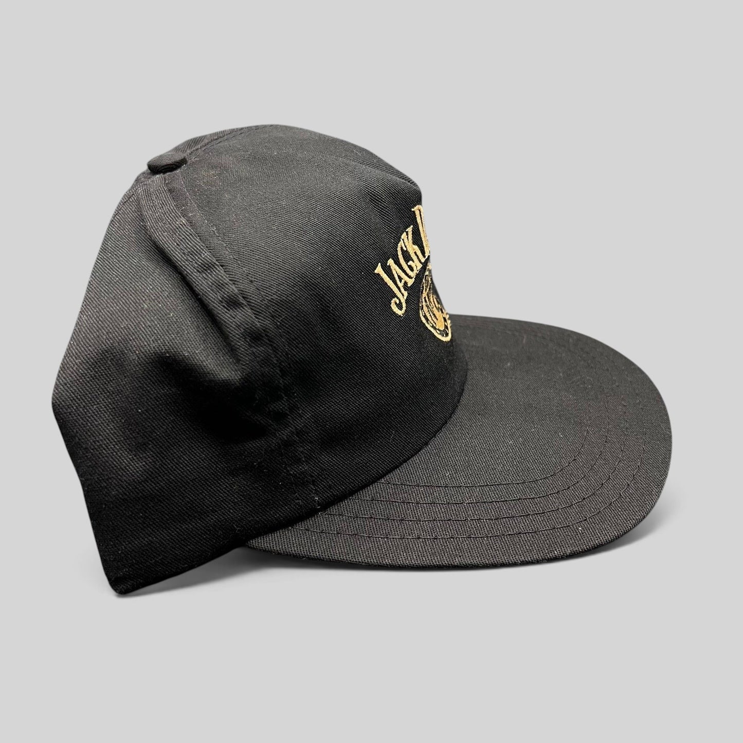 Raree Finds vintage 90s black Jack Daniel’s snapback hat with gold embroidered Old No. 7 logo on a six-panel crown.