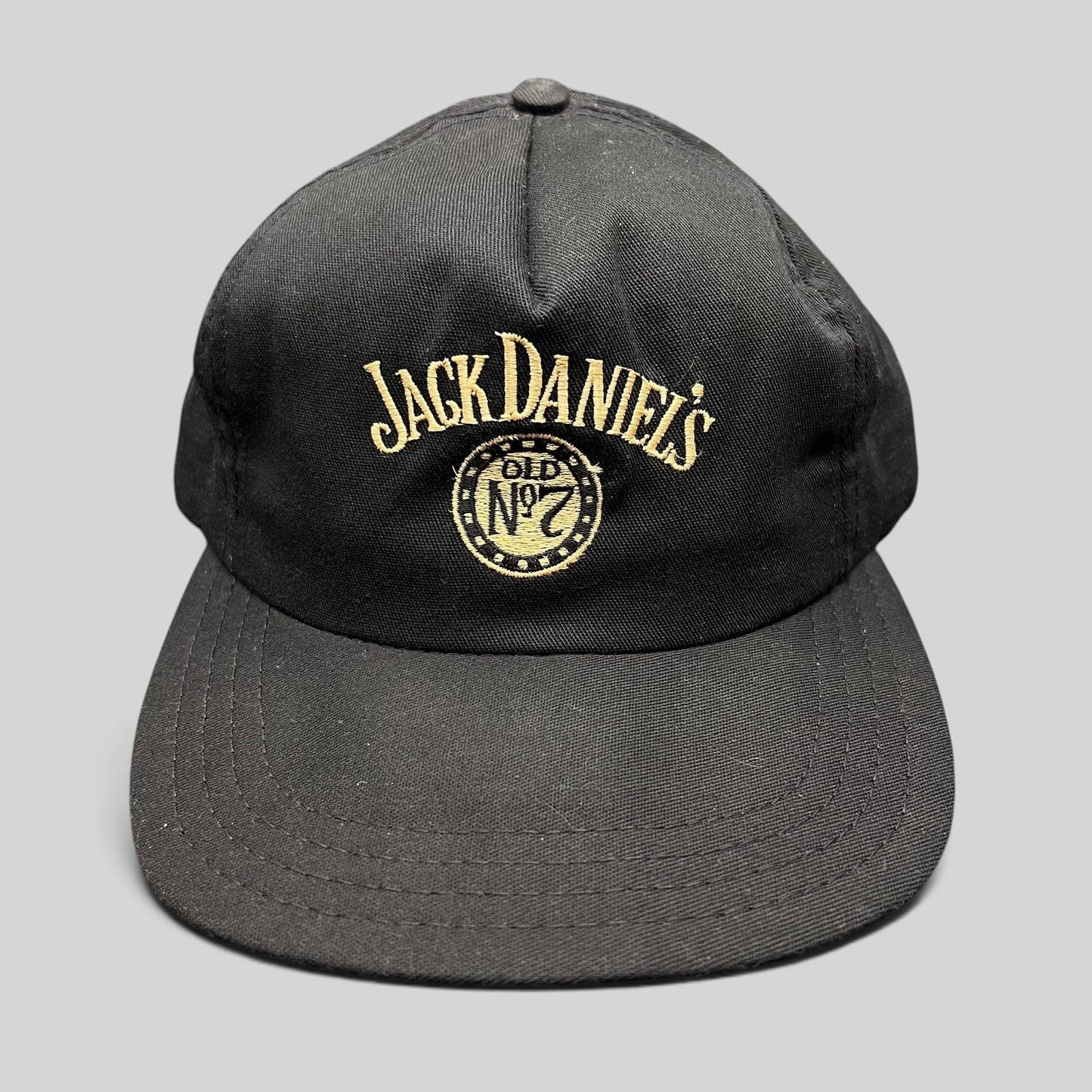 Raree Finds vintage 90s black Jack Daniel’s Old No. 7 snapback hat with gold embroidered logo and structured crown.