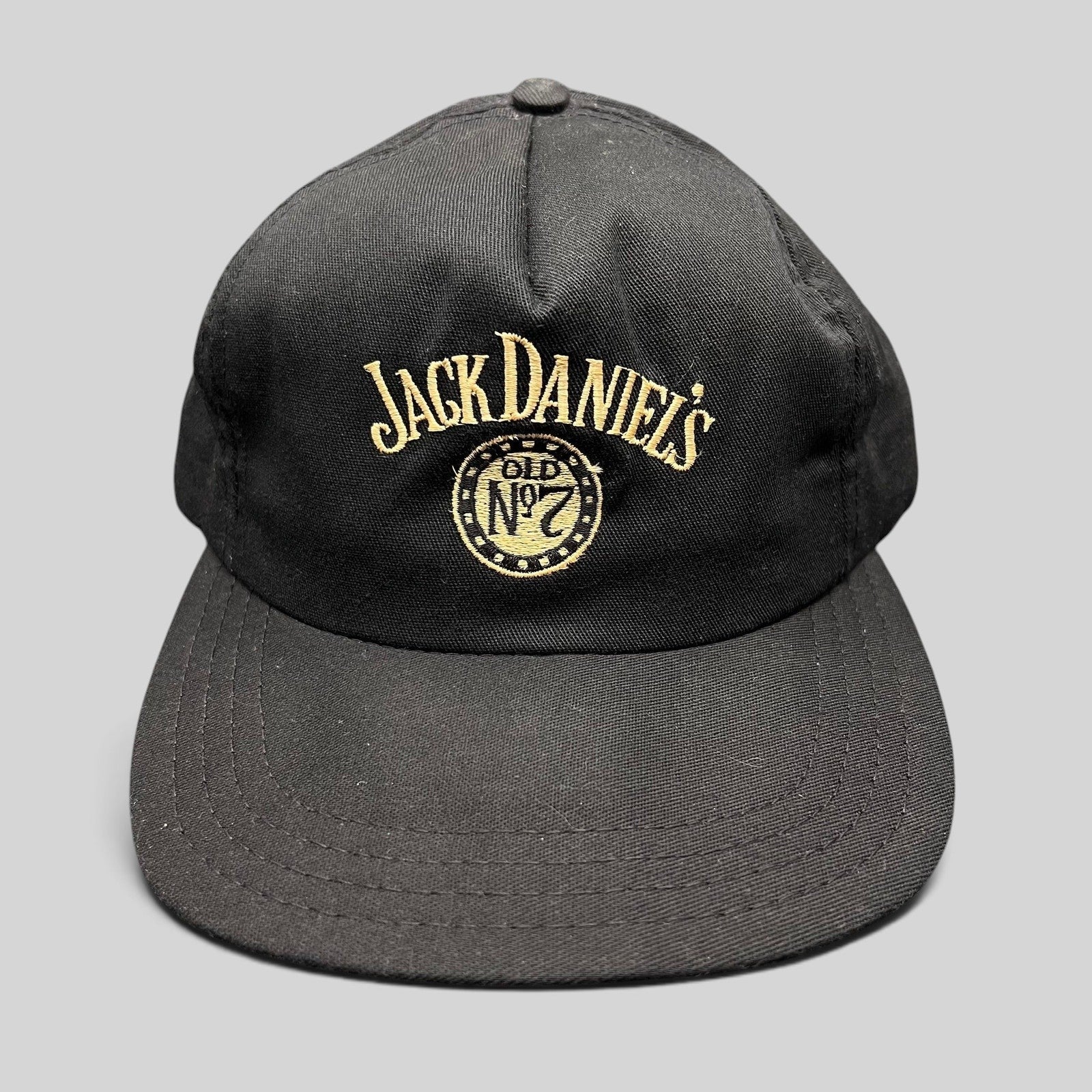 Raree Finds vintage 90s black Jack Daniel’s Old No. 7 snapback hat with gold embroidered logo and structured crown.