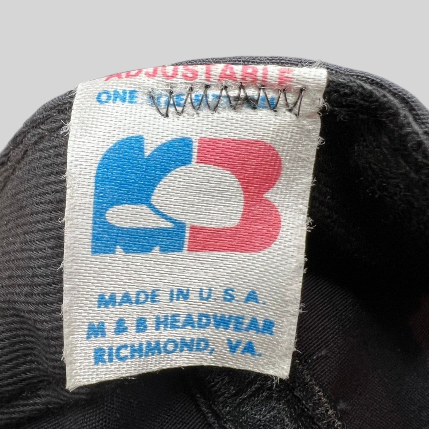 Raree Finds vintage M&B Headwear tag showing Made in USA and Richmond VA details on a black cotton snapback hat