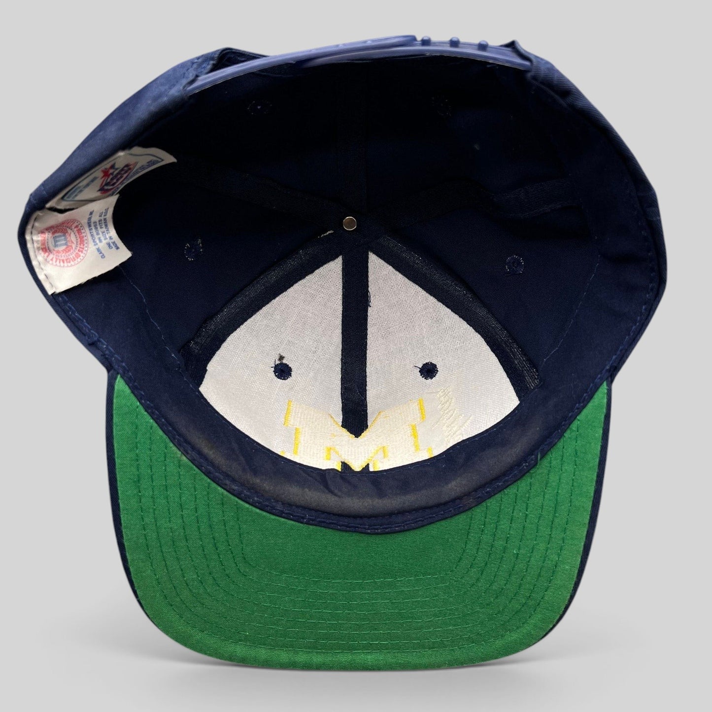 Raree Finds vintage Michigan Wolverines snapback hat interior showing green undervisor and collegiate tag