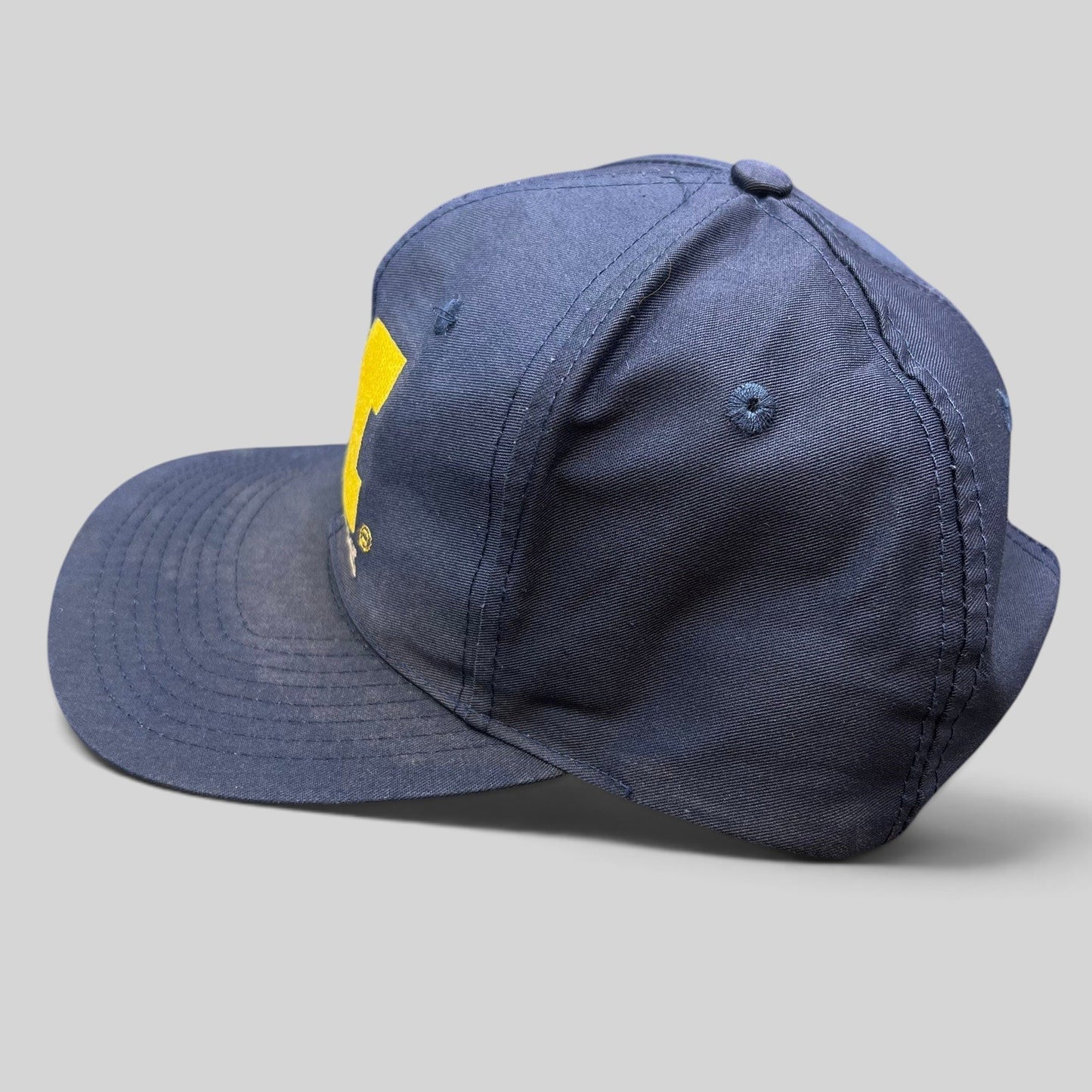 Raree Finds vintage navy Michigan Wolverines snapback hat with maize embroidered block M logo and green undervisor.