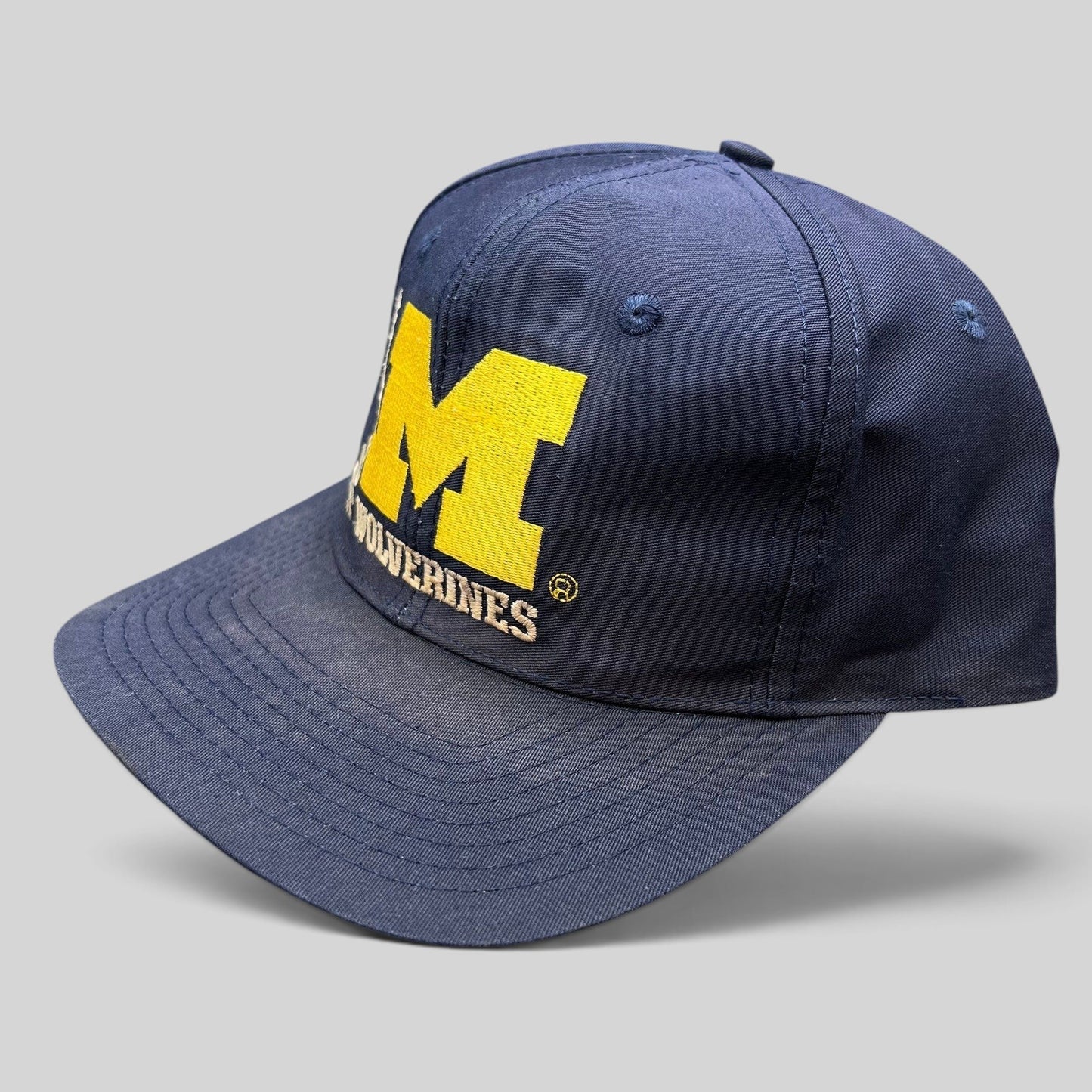 Raree Finds vintage navy Michigan Wolverines snapback hat with maize embroidered block M logo and green undervisor.