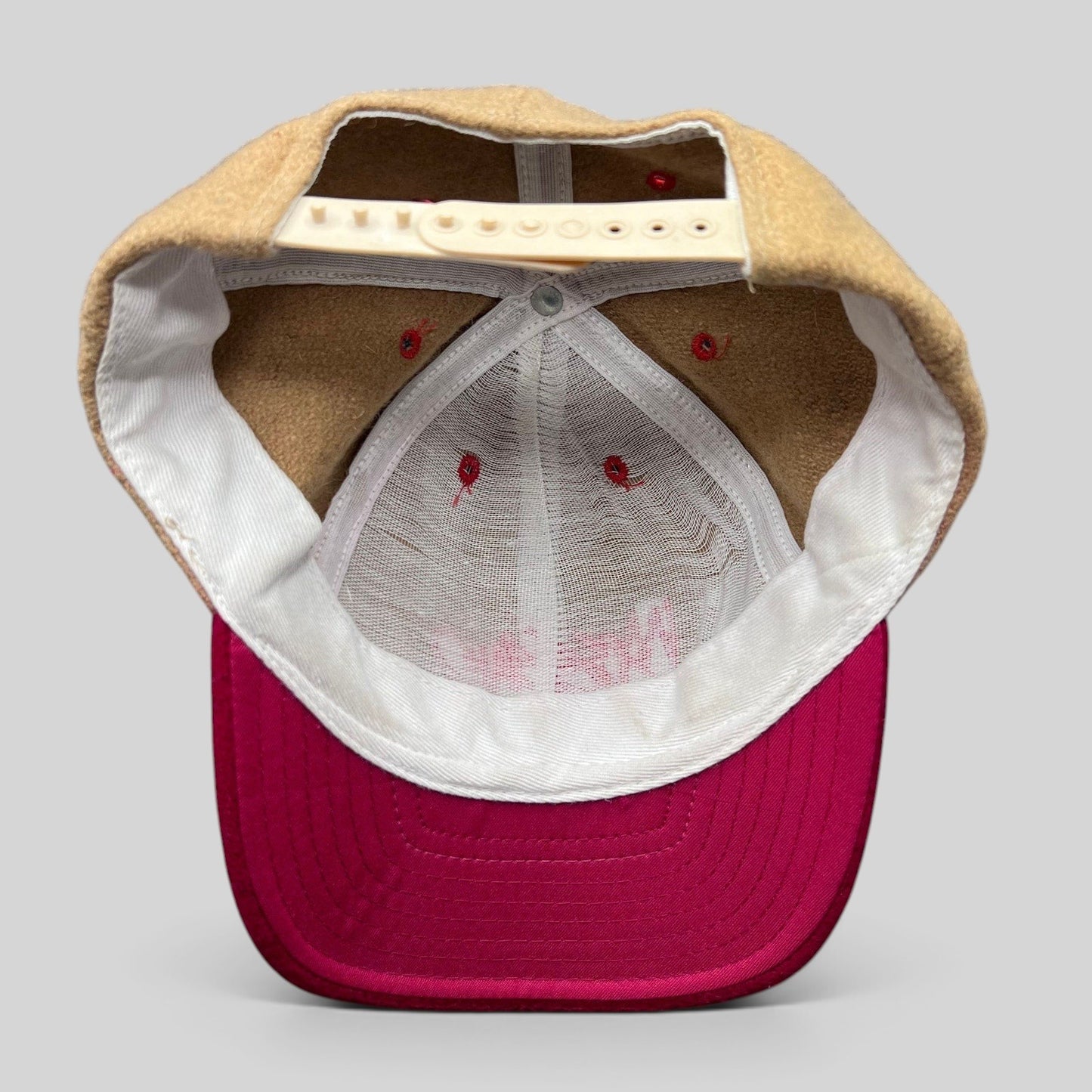 Raree Finds vintage Mossimo wool snapback hat interior view showing camel crown, red brim, and adjustable strap.