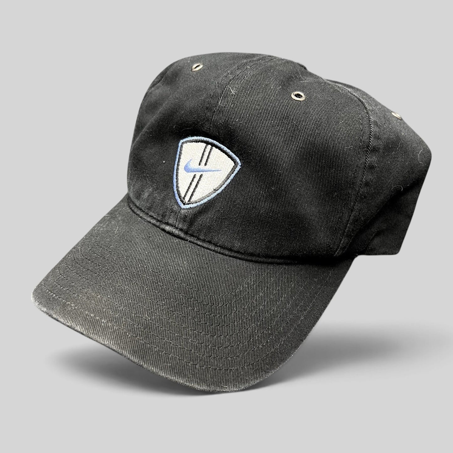Raree Finds vintage black Nike soccer strapback hat with an embroidered shield crest and blue swoosh logo.