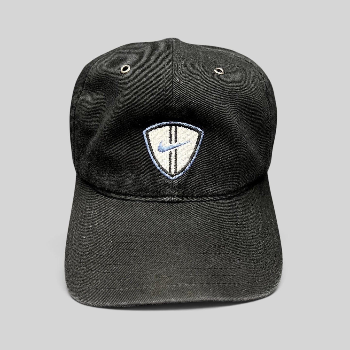 Raree Finds vintage black Nike soccer strapback hat with an embroidered shield crest and blue swoosh logo.