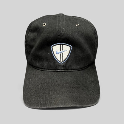Raree Finds vintage black Nike soccer strapback hat with an embroidered shield crest and blue swoosh logo.