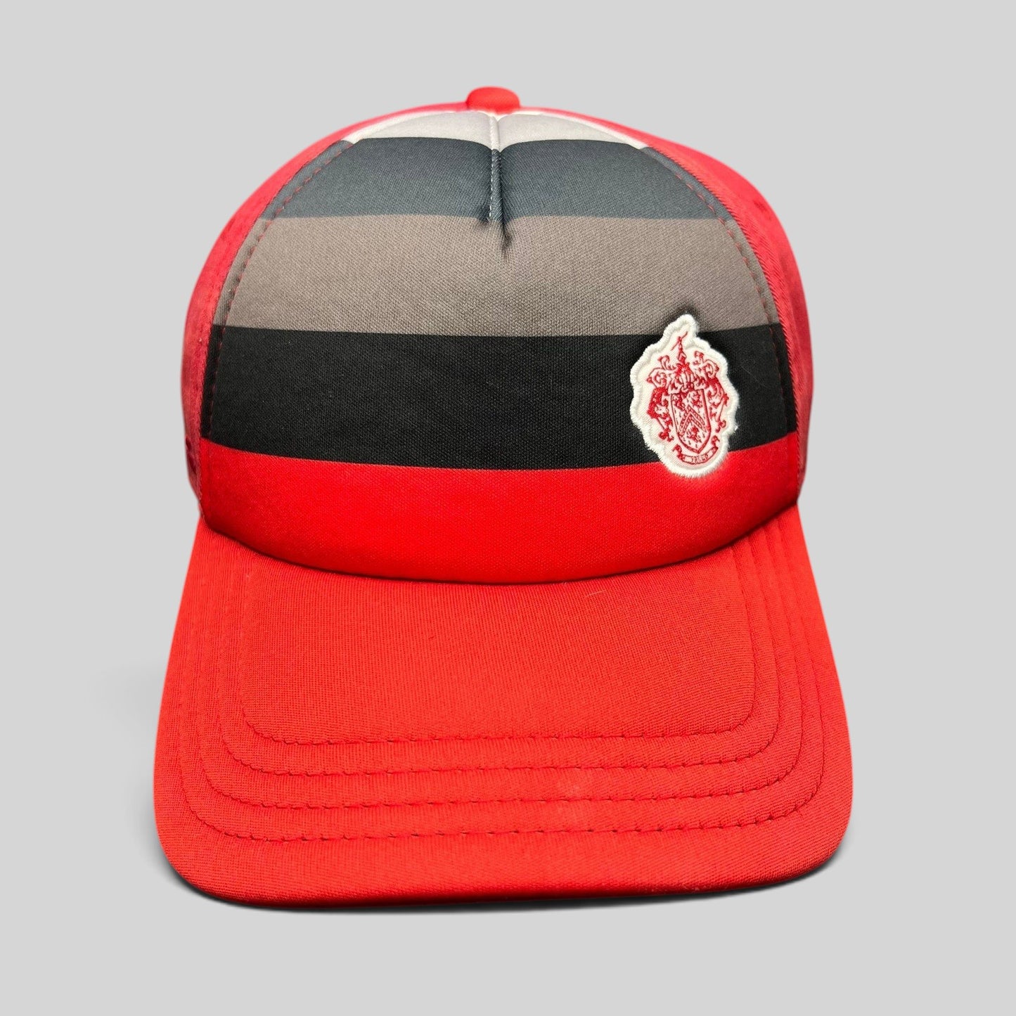Raree Finds vintage Pukka Headwear red golf hat with black and gray striped front panel and embroidered crest patch