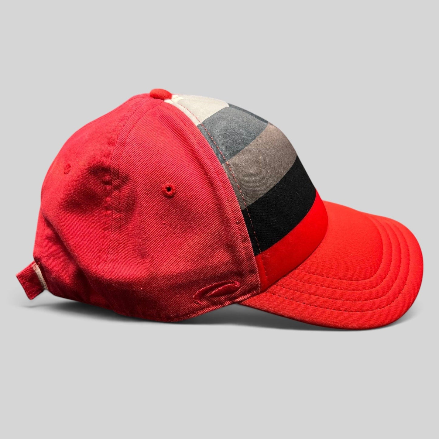 Raree Finds vintage Pukka Headwear strapback golf hat in red with black and gray striped front panel detail.
