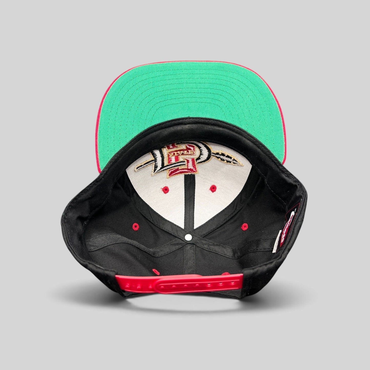 Raree Finds vintage San Diego State Aztecs snapback hat with green undervisor and red adjustable plastic closure