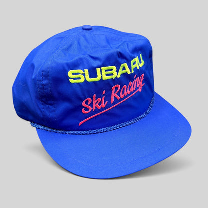 Raree Finds vintage blue nylon Subaru Ski Racing strapback hat with neon embroidery and rope detail on the brim.