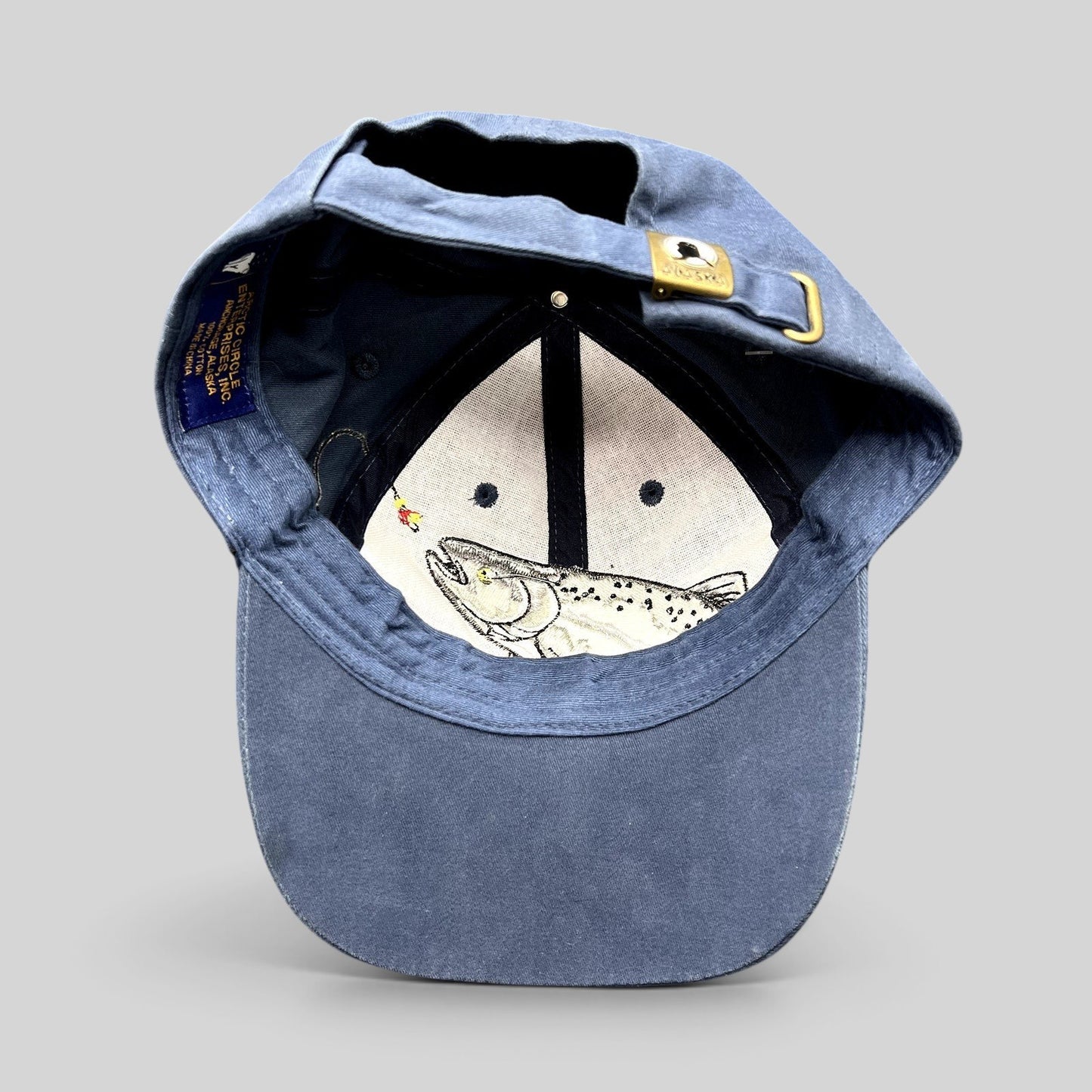 Raree Finds vintage blue cotton strapback hat featuring an embroidered rainbow trout and brass Alaska buckle