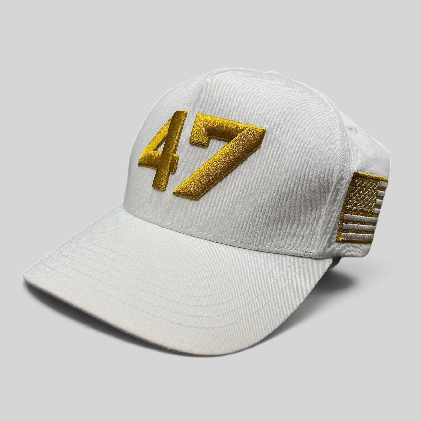 Raree Finds white cotton snapback hat with gold 47 embroidery and a gold American flag patch on the side.